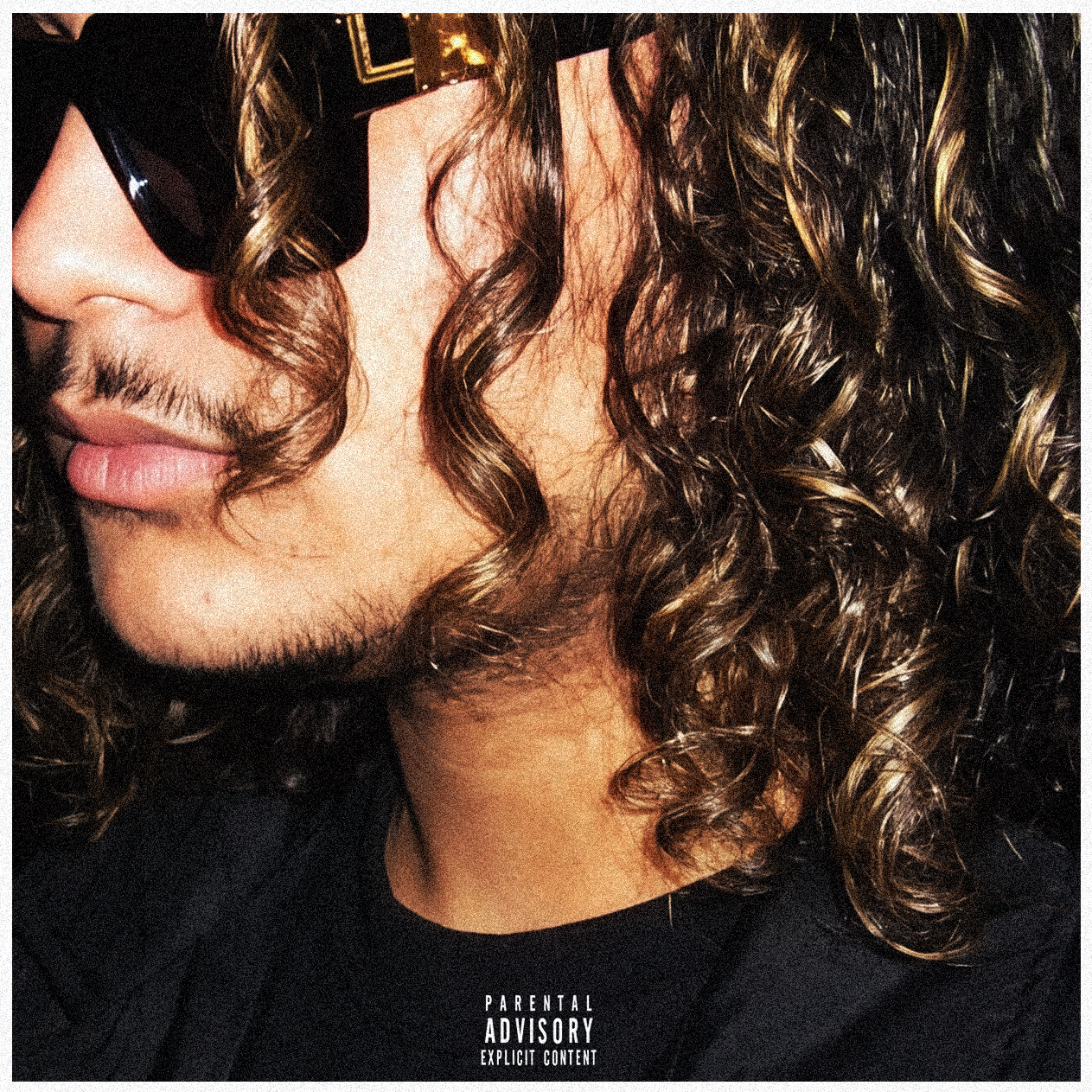 Cover artwork for NDA: a grainy close-up portrait of PRXD. JAY in black angular sunglasses, framed by dark curls, with a Parental Advisory label.